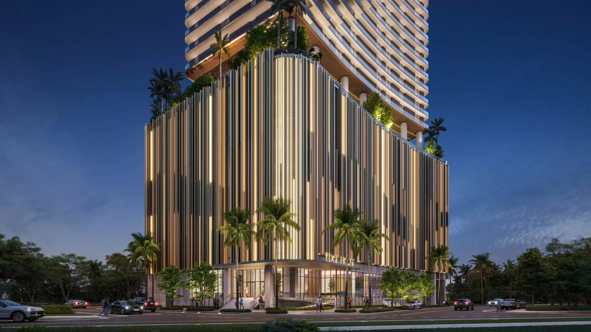 A contemporary building's lower levels featuring a striking vertical strip facade with illuminated accents, surrounded by palm trees and lush greenery. The entrance, labeled 